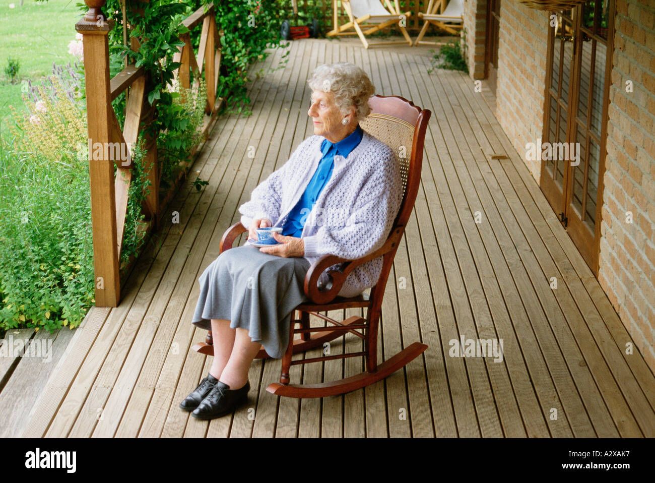 6d048a2f-f993-4e28-969c-145d3e42487c-old-woman-sitting-in-rocking-chair-on-veranda-at-home-A2XAK7-3349895935.jpg